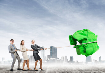 Young business people outdoors and huge paper ball as symbol of creativity