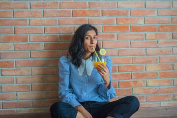 Young indian woman drinking orange juice