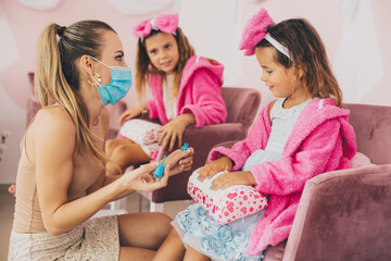 Children in spa center having a nail treatment.