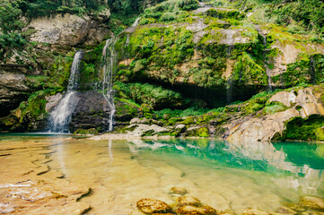 View of crystal clear water and small pond with waterfalls in the middle of the Triglav national...