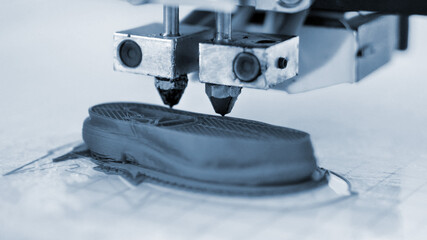 3D printer prints the form of molten plastic blue close-up