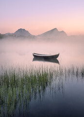 Very peaceful summer night with wooden boat and fog in Lofoten, Norway - 426586622