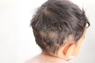 Fototapeta premium A long, black haired Asian boy is pretending to cut his hair unattractive. Looks disheveled and unkempt Because of being punished for doing wrong. Take photo in Thailand