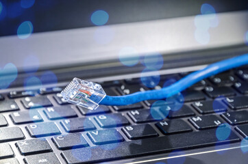 Internet LAN cable on a computer keyboard symbolizing cyberspace and connectivity