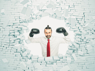 businessman with boxing gloves breaks a brick wall.