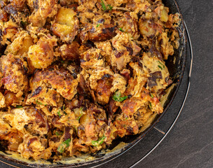 fried potatoes with eggs and ham in a frying pan from above