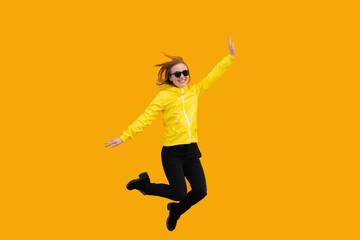 Fototapeta na wymiar Jumping a young woman on yellow background