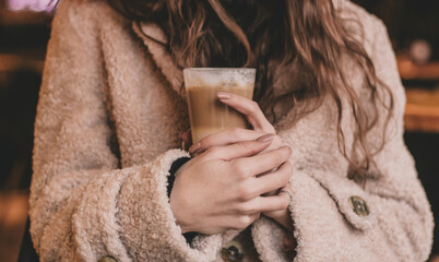 the hands of a woman holding a latte in a restaurant