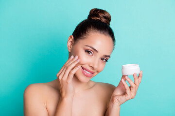 Portrait of attractive cheerful girl holding in hands applying cream collagen freshness isolated...