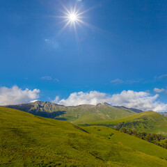 green mountain ridge under a sparkle sun