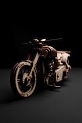 Fototapeta na wymiar Designer of wood in the shape of a motorcycle on a black background