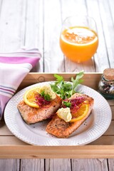 Grilled salmon fish with orange butter and rocket salad
