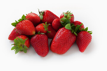 Group of fresh, ripe red strawberries with green leaves on white background