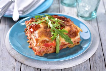 Lasagne with ham and bechamel sauce with rocket leaf on top