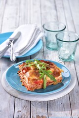 Lasagne with ham and bechamel sauce with rocket leaf on top