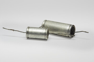 metal-paper capacitors with black flat ends. pair of vintage electronic parts of circuit of tube...