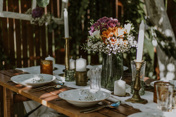 Wedding table setting with glasses, candles and flowers