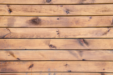 Fototapeta na wymiar Close-up wooden surface. Old fence made of wooden beams. Grunge wooden texture with horizontal planks. Wood texture with copy space.
