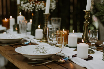 Wedding table setting with glasses, candles and flowers