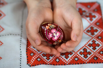 Сolored easter eggs with the traditional ukrainian slavic designs. Beautiful pysanka handmade - ukrainian traditional in child's hands on traditional embroidered tablecloth vyshyvanka