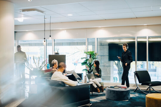 Male and female colleagues discussing in office - Powered by Adobe