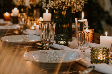Wedding table setting with glasses, candles and flowers