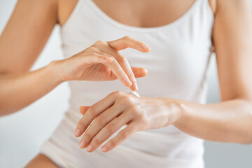 Obraz na płótnie Canvas Close up of woman applying lotion on hands
