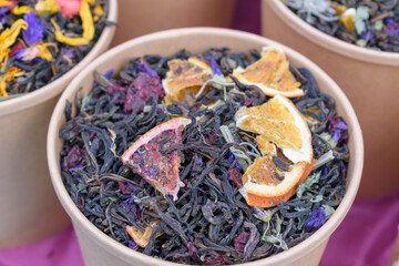 Tea with fruit and flower additives. Dry tea in a paper cup.