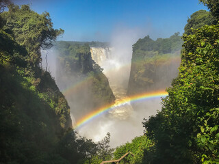 The iconic Mosi-Oa-Tunya waterfall aka Victoria Falls, with a rainbow. View from the Zimbabwe side.
