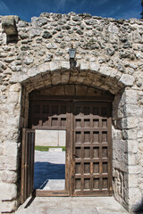 Portón de madera en muro de piedra que accede al castillo medieval de Cuellar, Segovia