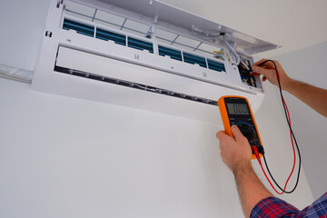 Air conditioner repair and maintenance. The engineer diagnoses the electrical part of the indoor...