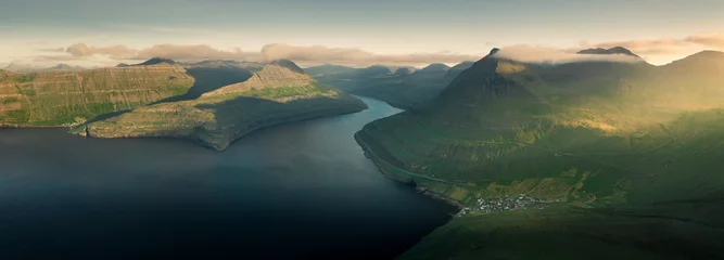Rollo Panoramic view of mountain landscape at Hvithamar near the town of Gjogv on the Faroe Islands, island Eysturoy with fjord at sunset, sun rays from side. © Bastian Linder