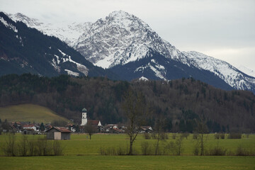 Winteruntypisches Bergpanorama in den Allg&auml;uer Alpen mit gr&uuml;nen Talflanken und Schnee nur auf den Gipfeln
