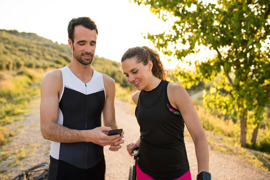 Couple of triathletes share the statistics on the mobile after training with the bicycle
