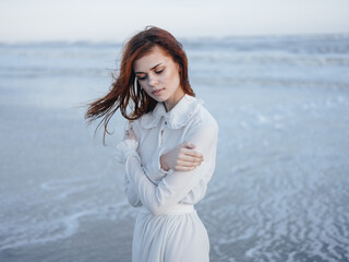 Fototapeta na wymiar Woman in white dress on the ocean waves beach nature