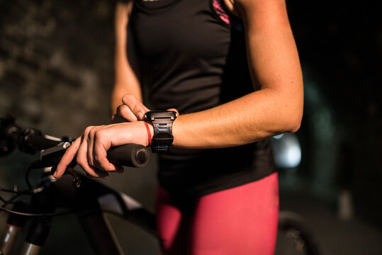 Athlete woman in tunnel synchronizes her smart watch to see her statistics