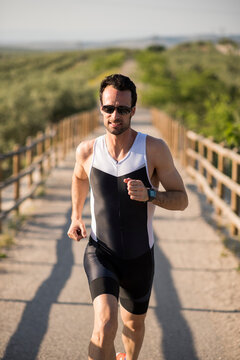 Young triathlete runs down a path outdoors giving one last effort to reach his destination