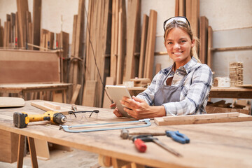 Young woman as a craftsman trainee with computer