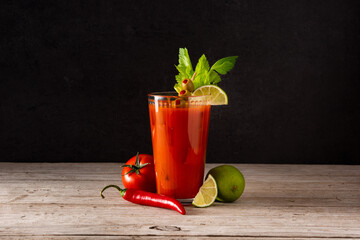 Bloody Mary cocktail in glass on rustic wooden table. 