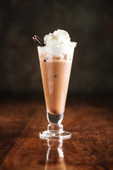 Coffee milkshake cocktail on the wooden table with reflection