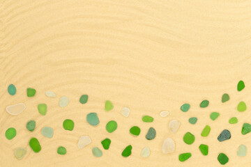 Summer background with green sea glass on the sand