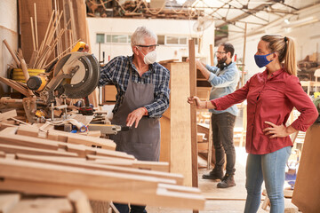 Instructor shows apprentice how to work with a chop saw