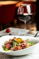 Salad with Prosciutto, ham and grapefruit jamon, salad mix, grapefruit, cherry tomatoes, parmesan cheese. Cold snacks. Food recipe background. Close up