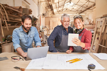 Craftsmen team with computer in the joinery