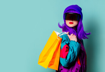 Stylish girl in cyber punk glasses and 80s tracksuit hold shopping bags