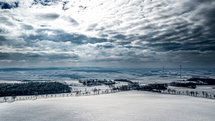 Fototapeta na wymiar Snowy Winter Landscape With Remote Settlements And Wind Turbines In Austria