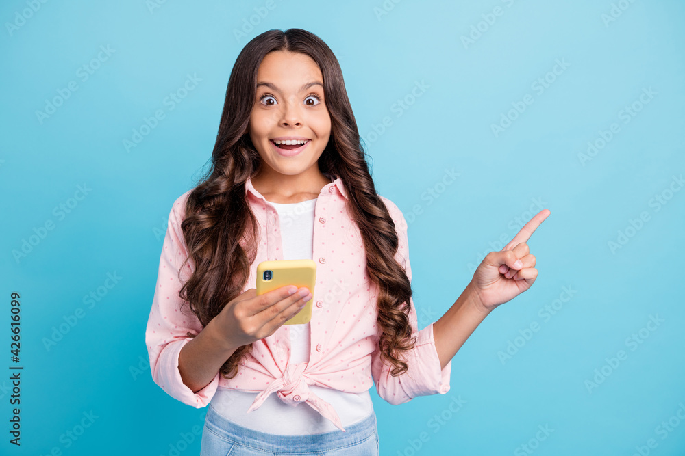 Poster Portrait of brunette curly hairstyle beautiful girl direct finger empty space isolated on blue color background