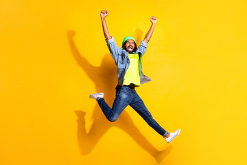 Full size photo of young happy excited smiling shouting afro man jumping in victory isolated on...