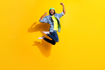 Fototapeta na wymiar Full size photo of young handsome excited smiling man jumping in victory isolated on yellow color background