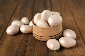 Raw jackfruit seeds in bowl on wooden table, closeup